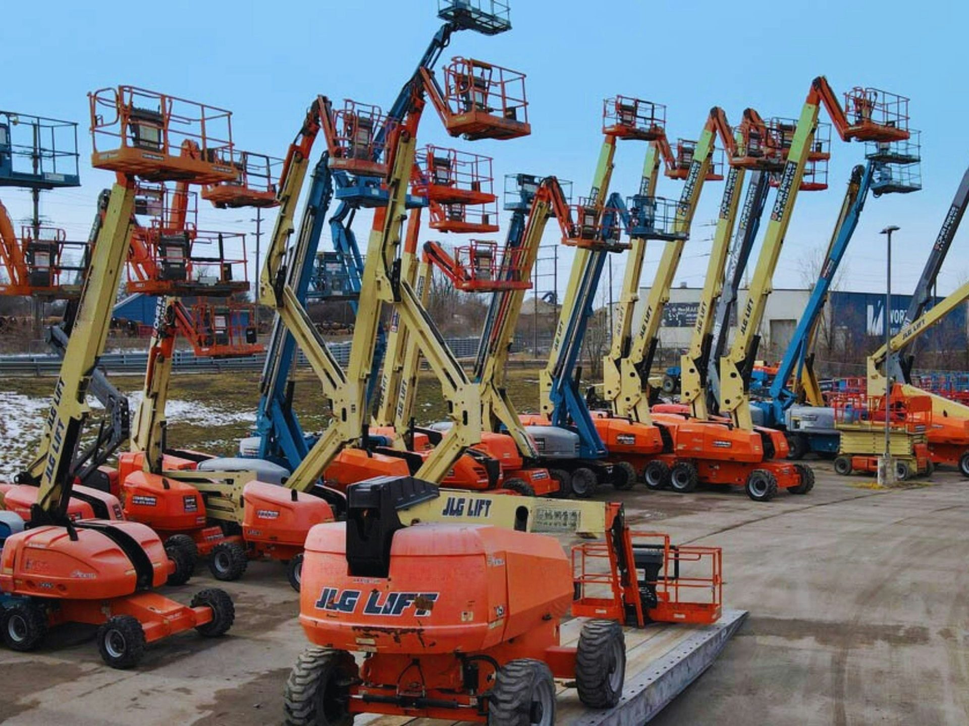 Row of JLG boom lifts on a lot